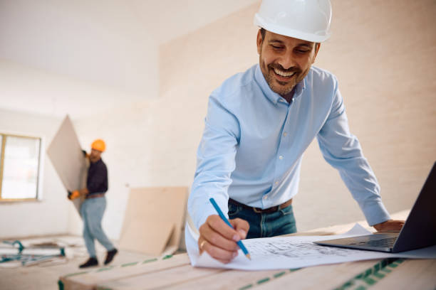 Expert remodeling contractor in Hollywood working on a laptop at a construction site, planning home renovation projects