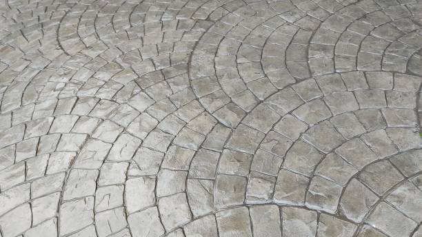 A concrete patio with a distinct circular design, emphasizing contemporary patio design, outdoor construction, and modern aesthetics for a stylish and functional space.