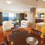 A stylish living room and dining area featuring a stunning ocean view, showcasing custom remodeling details.