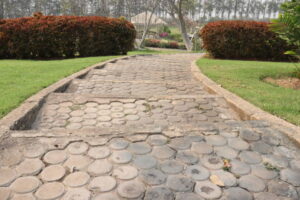 A stone path leading to a grassy area, showcasing a well-designed outdoor space with stamped concrete patios.