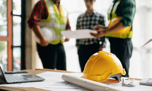 A group of construction workers gathered around a table, discussing plans and collaborating on a project.